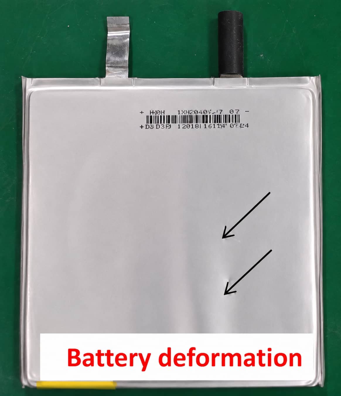Wrinkled and deformed lithium-ion pouch cell after long-cycle testing, showing surface dents and structural deformation.